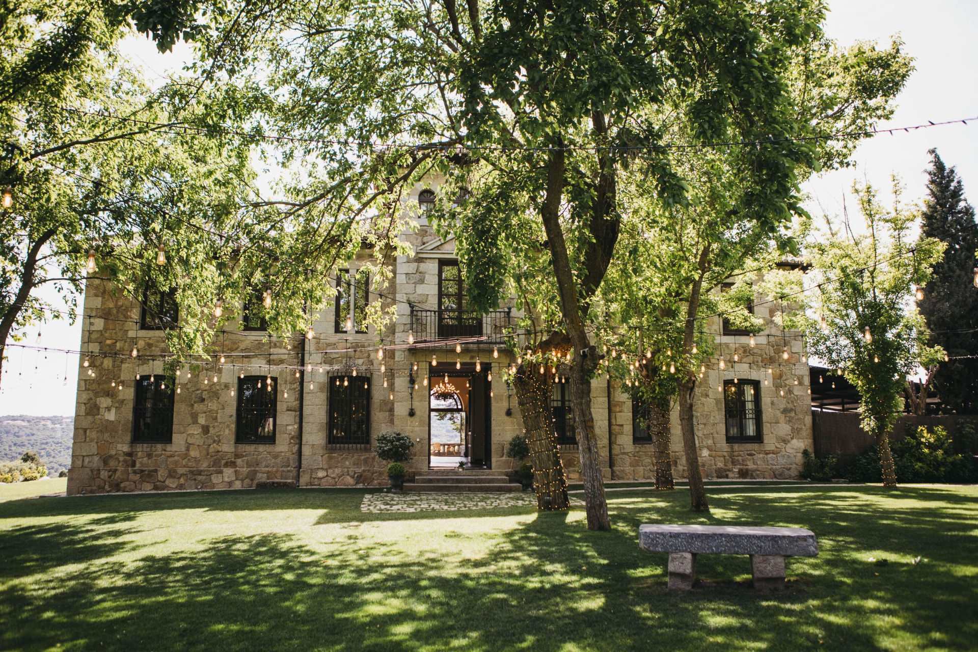 The stone house at Finca el Gasco framed by trees and festoon lights